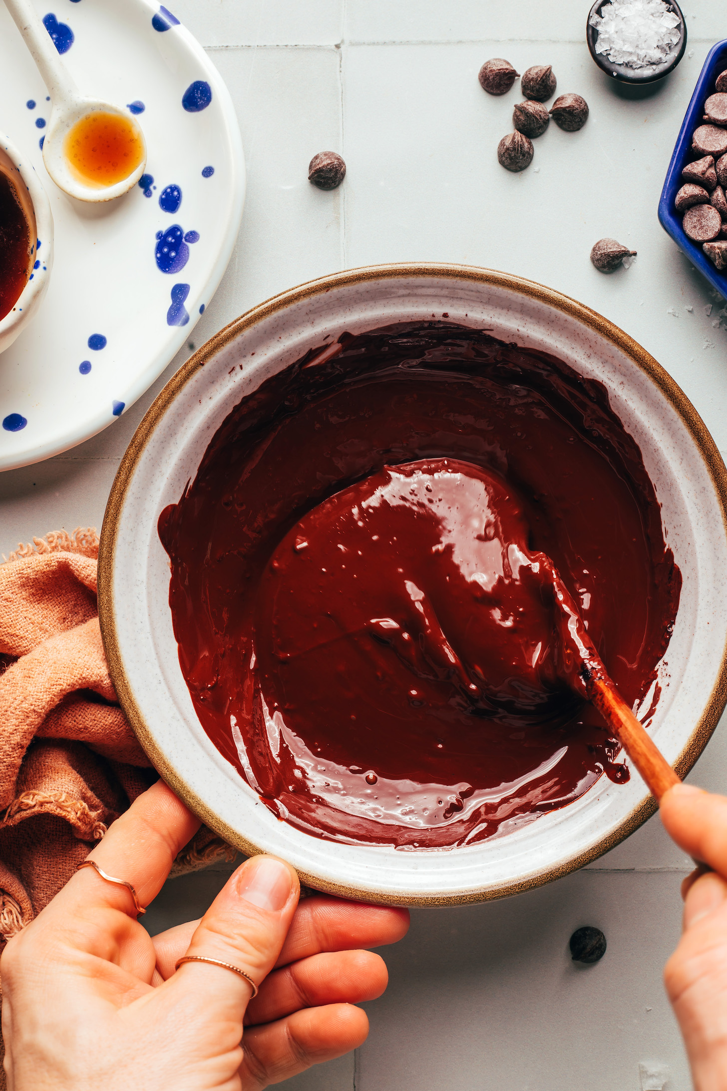 Stirring melted dark chocolate in a ceramic bowl