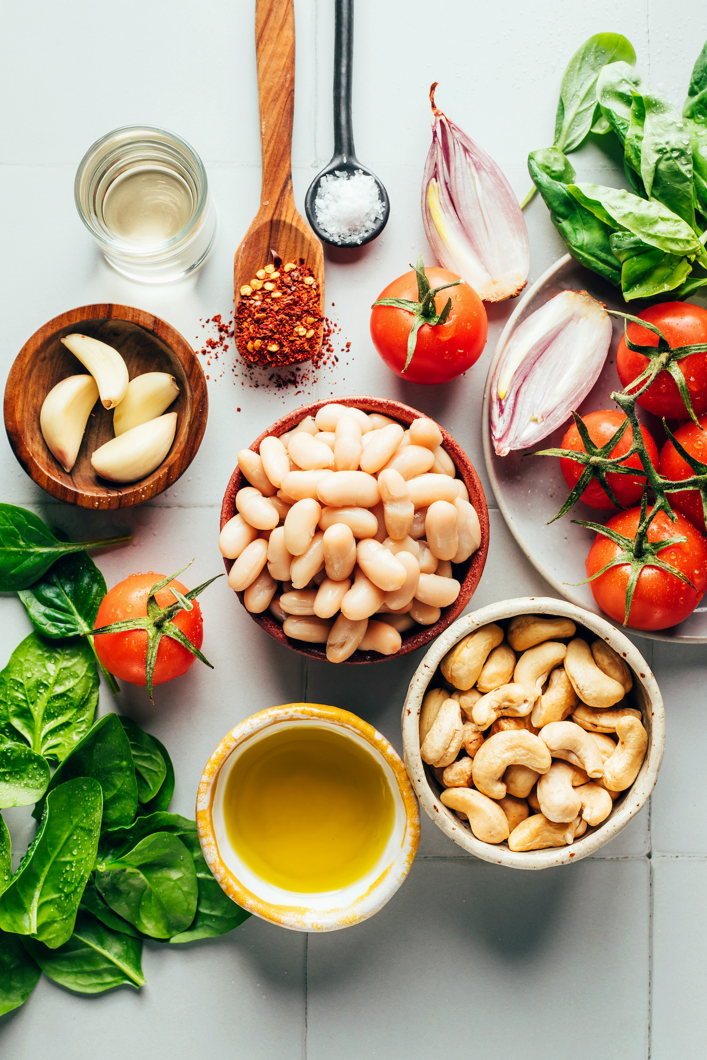 Cashews, olive oil, white beans, tomatoes, spinach, garlic, white wine, red pepper flakes, salt, and shallot
