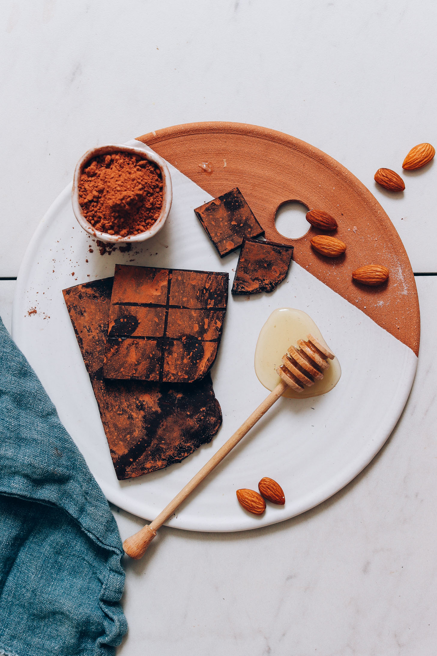 Ceramic and clay tray with almonds, cacao powder, and homemade Honey Mama's Bars