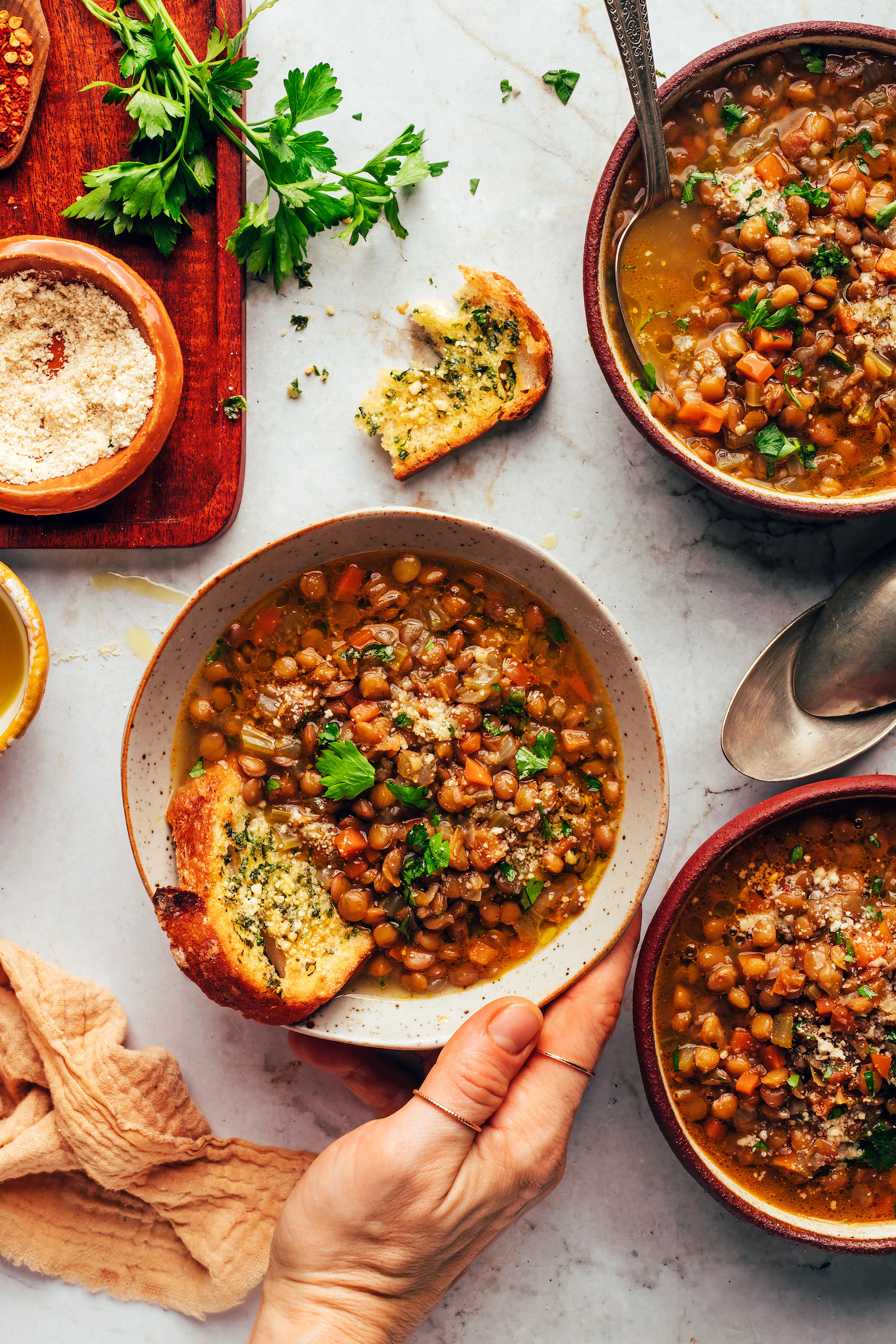 Bowls of Italian lentil soup with slices of garlic bread