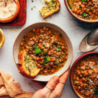 Bowls of Italian lentil soup with slices of garlic bread